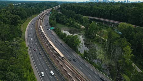 train and cars passing through georgia state route 400 with path400 in buckhead, atlanta, georgia