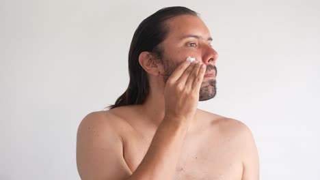 man applying skincare product to his face