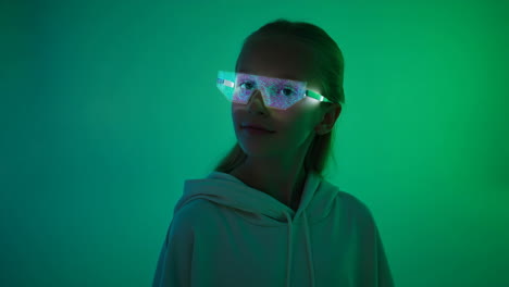 young girl wearing futuristic glowing glasses in green light