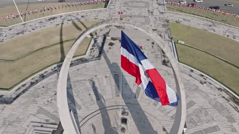 slow-motion of flag waving over triumphal arch in plaza de la bandera, santo domingo in dominican republic