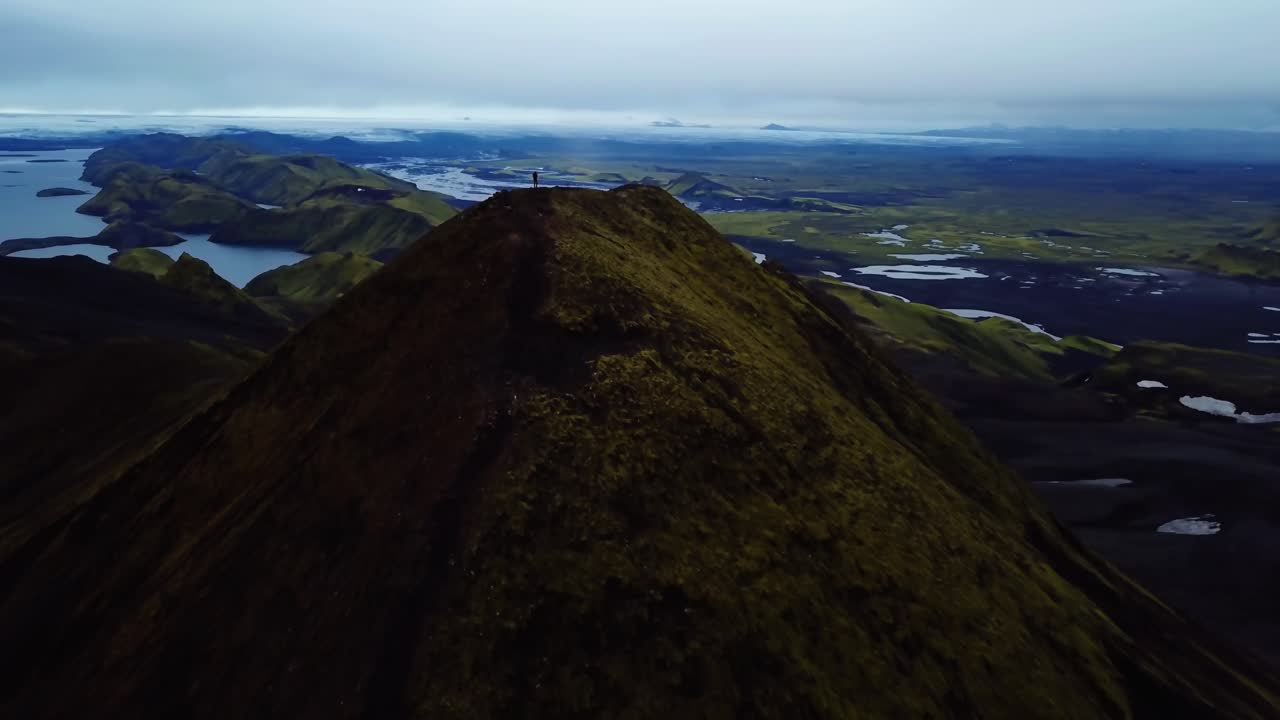아이슬란드 고지대의 산꼭대기에 서 있는 한 사람의 공중 드론 풍경