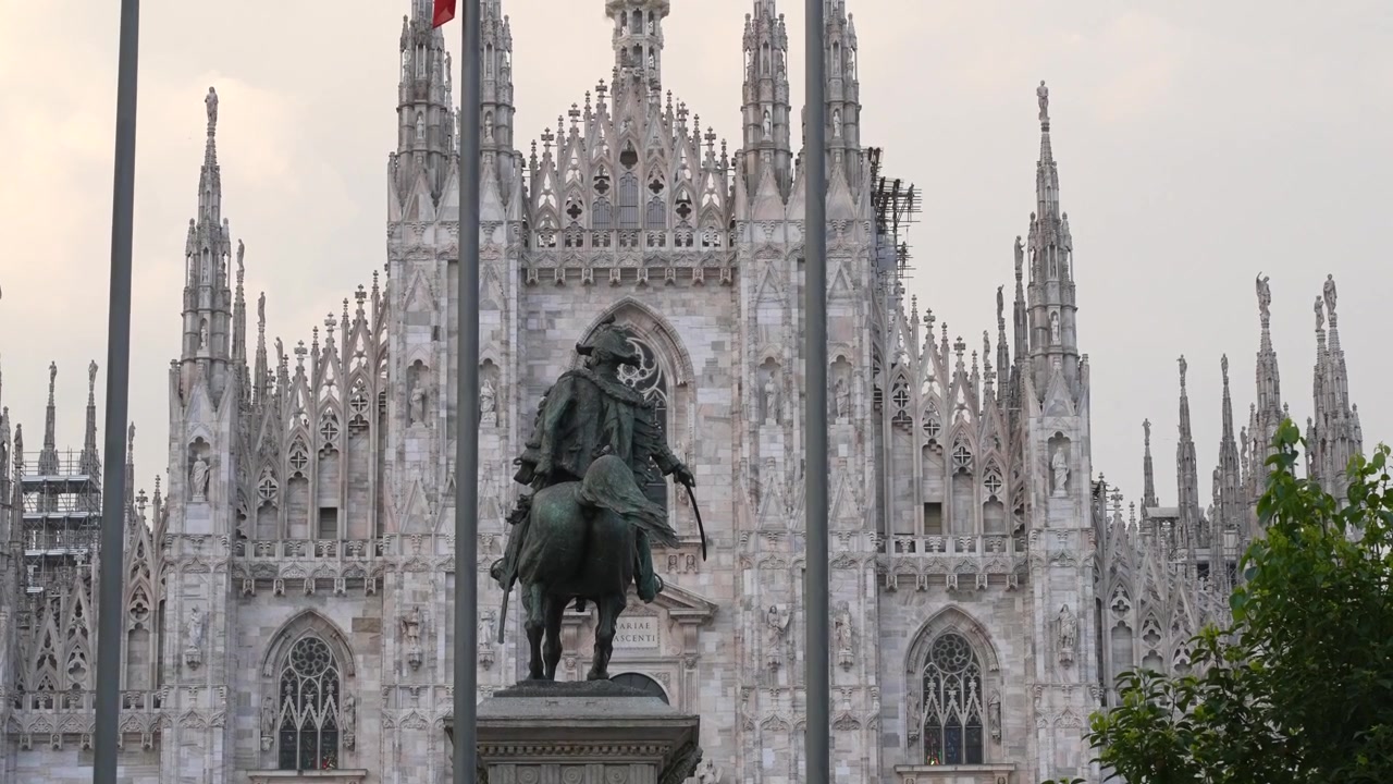 Toma a nivel de calle mostrando el Duomo de Milán elevándose detrás del monumento a Víctor Manuel II en la Plaza del Duomo. Arquitectura gótica histórica dominando la icónica plaza de la ciudad en Milán, Italia.