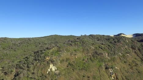 Rising-shot-as-a-stunning-vista-across-the-interior-of-Fraser-Island,-K�gari,-opens-up-with-its-spectacular-dunes-and-rain-forest-valleys