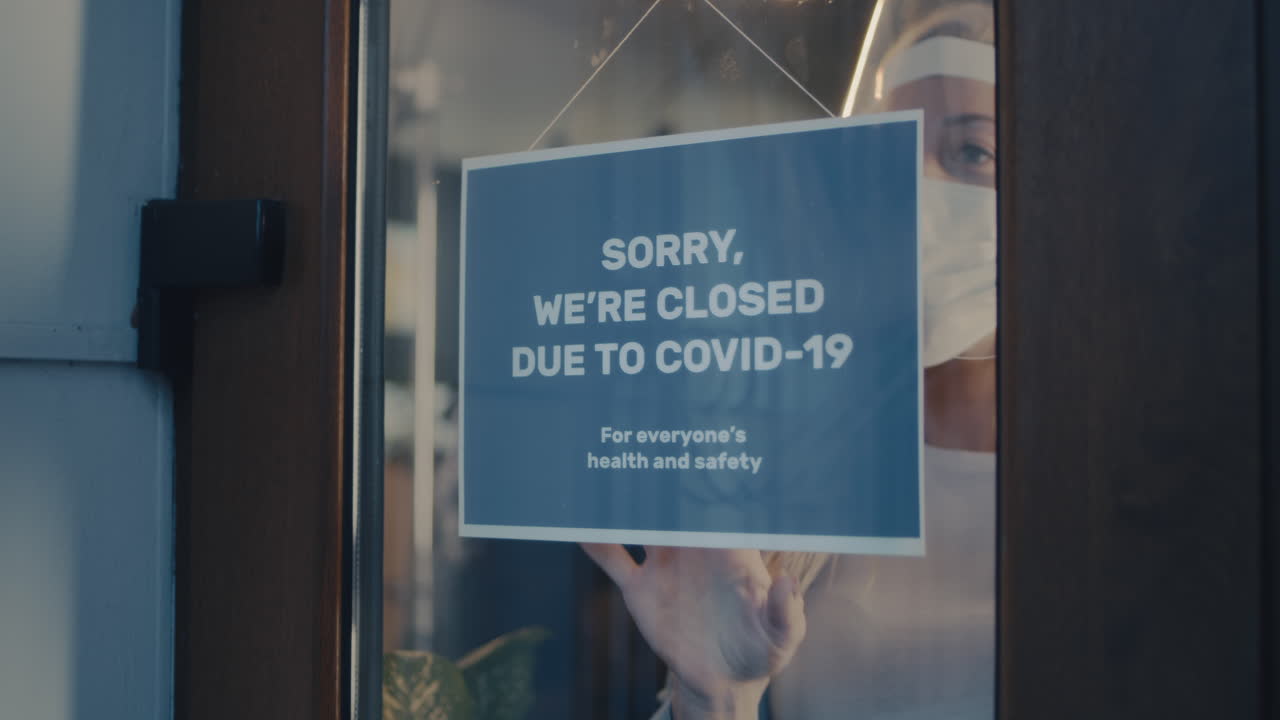 Business displaying "Sorry, we're closed due to COVID-19" sign