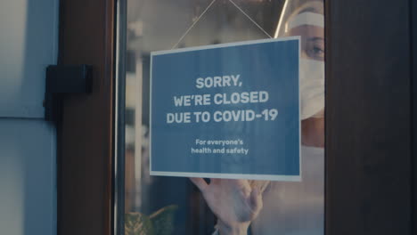 business displaying "sorry, we're closed due to covid-19" sign