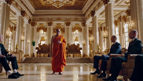 buddhist monk meets with businessmen in grand hall