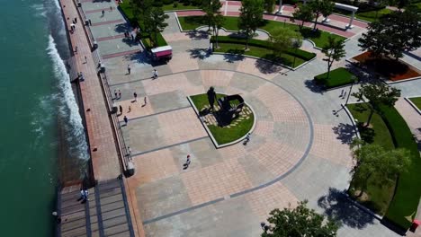 vista aérea del parque de la felicidad de weihai ubicado en el centro de la ciudad con personas rompiendo cerca de la escultura del pianista en la orilla del mar