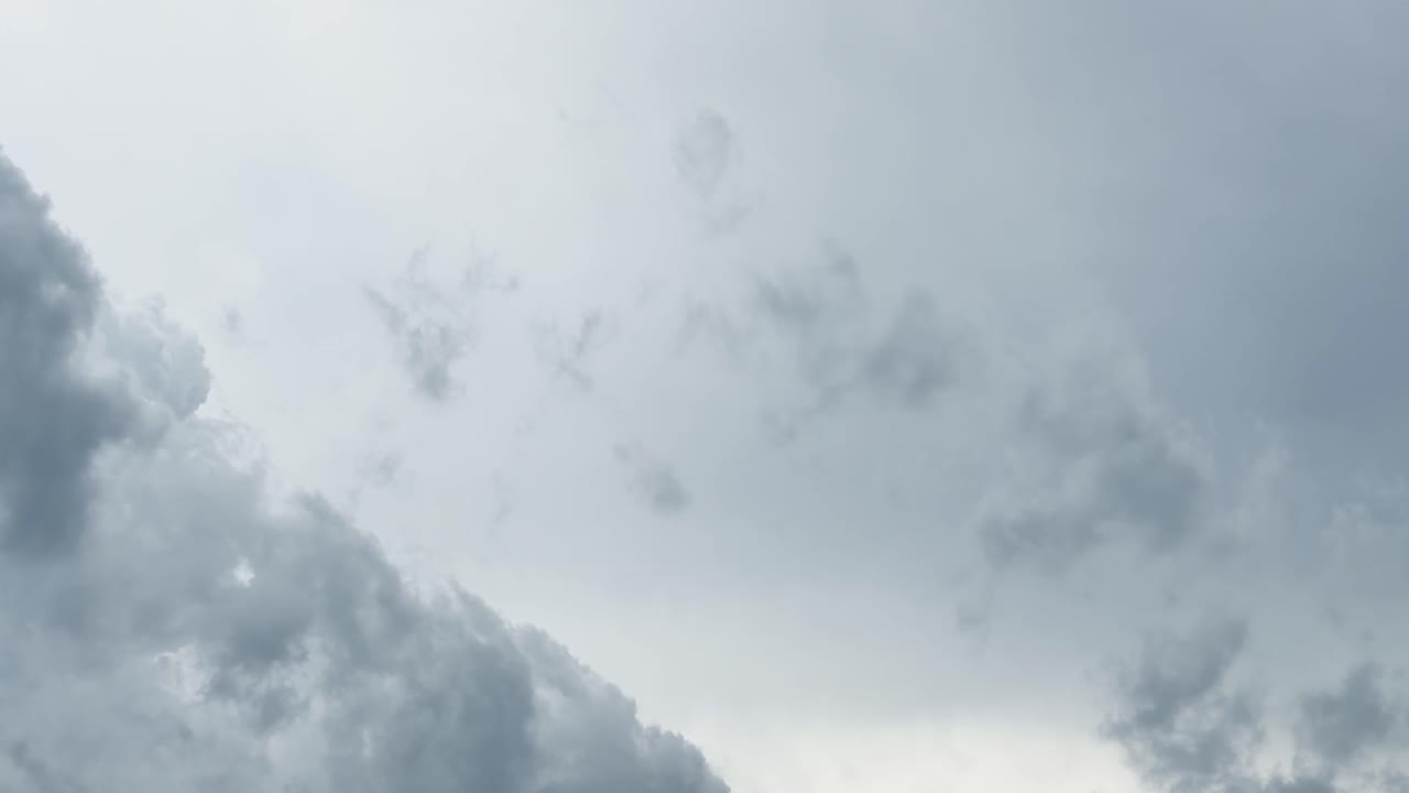 Dark storm clouds rapidly shift across a moody, overcast sky in smooth timelapse motion