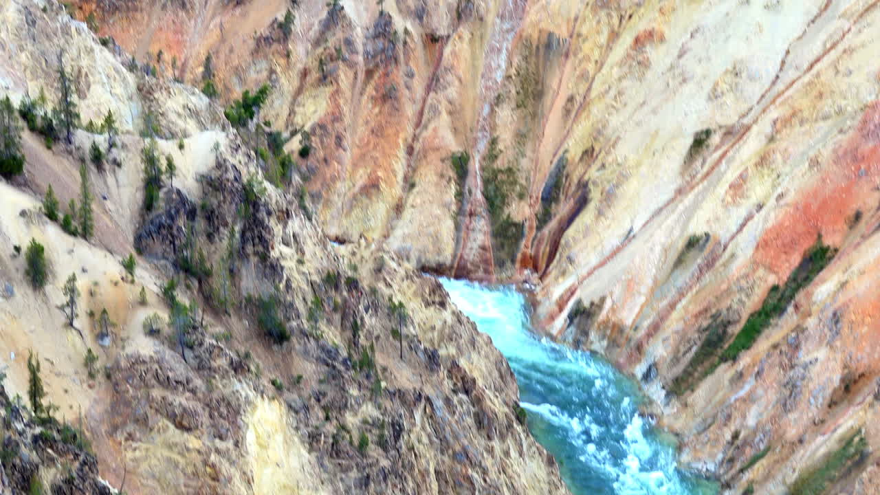 Rekaman dengan gerakan miring dan melintasi dinding ngarai berwarna-warni serta bebatuan di Grand Canyon Yellowstone.