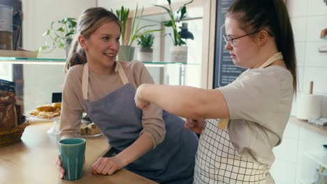 down syndrome girl chatting with her workmate in the cafe