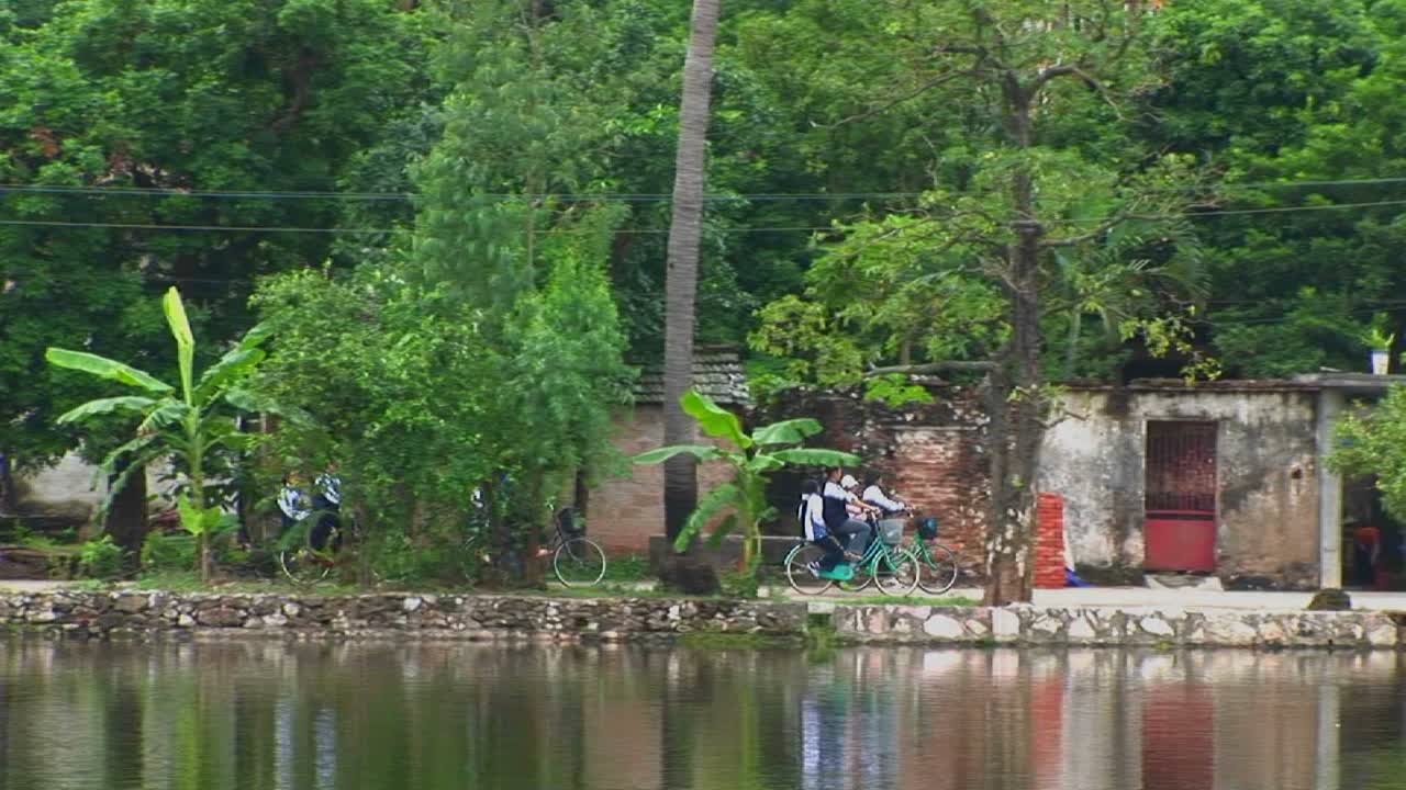 las niñas andan en bicicleta junto a un lago en vietnam
