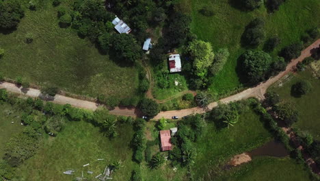 Vista-Aérea-De-ángulo-Alto-De-La-Casa-Y-Los-Campos-Verdes-Se-Inclinan-Hacia-Arriba-Para-Revelar-El-Lago-Gatun-En-Un-Día-Soleado