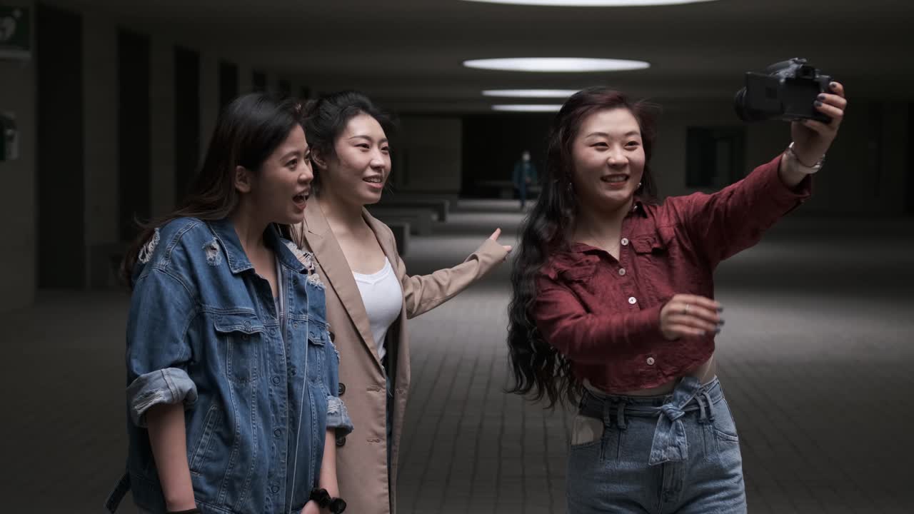 Asian female friends bloggers creating content for social media while making a video with a camera.