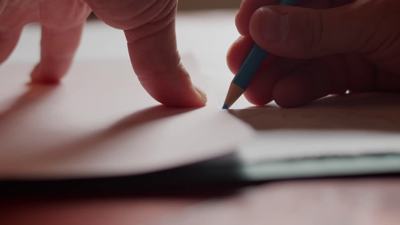 Fabric marker drawing close up onto fabric with hands visible.