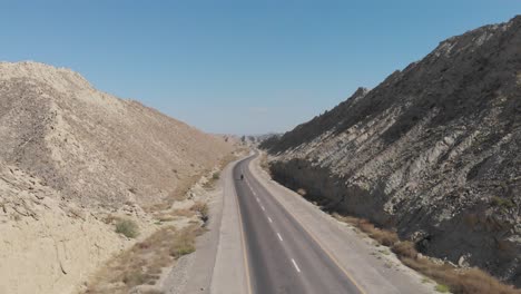 Aerial-Over-N10-Makran-Coastal-Highway-Road-Beside-Dramatic-Rock-Formations-In-Hingol-National-Park