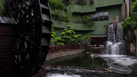 water wheel and waterfall in lush nan lian garden in hong kong