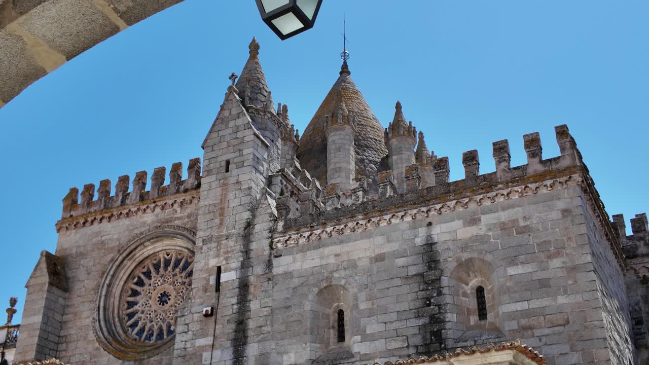 Exterior panning of Evora Cathedral showcasing buttresses, towers, and carved details