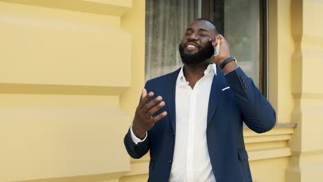 African-american-business-man-holding-pack-of-money-outside.-Guy-talking-phone