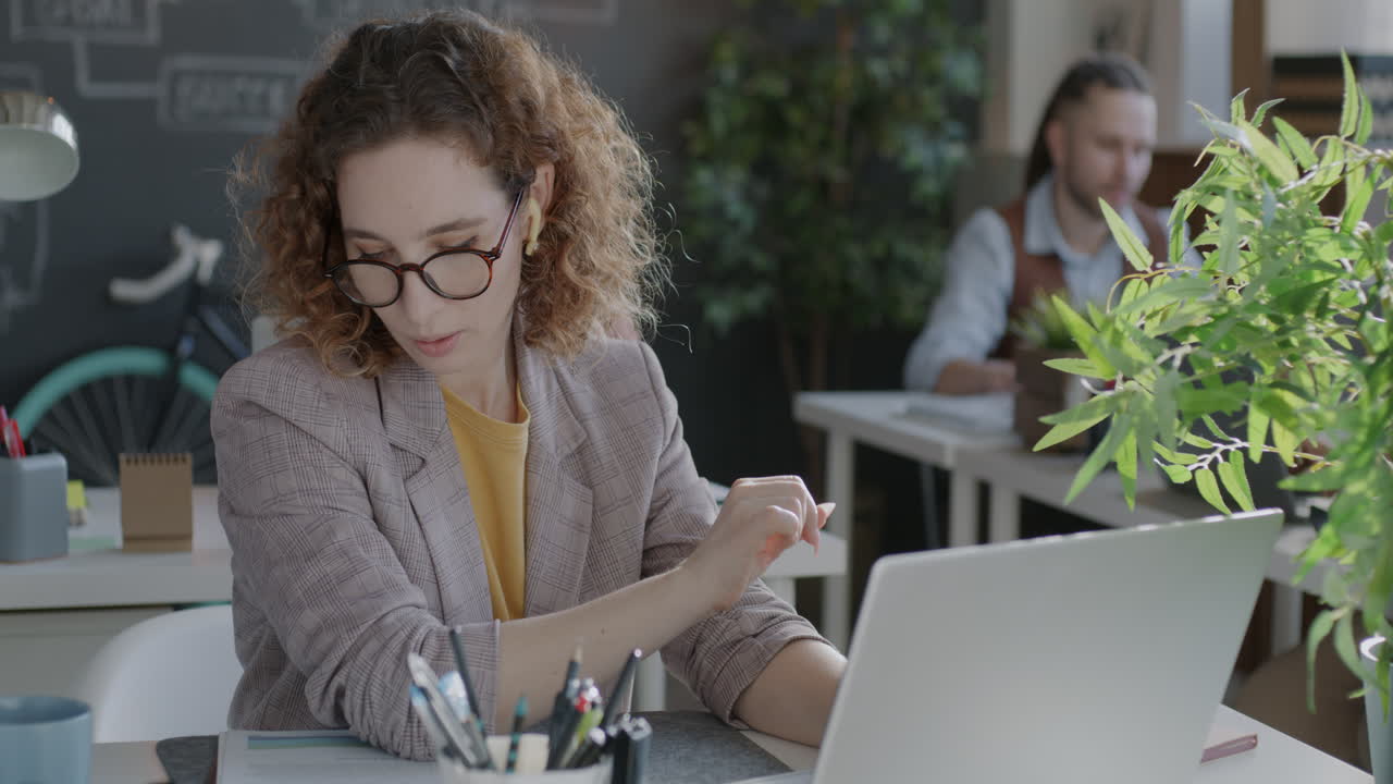 Mulher trabalhando em laptop em escritório moderno