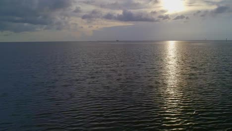 Flying-over-a-reflective-bay-during-sunset