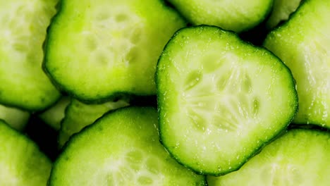 pepino, pedazos cortados de pepino verde apilados en una colina giran. círculos de pepinos frescos como fondo de comida