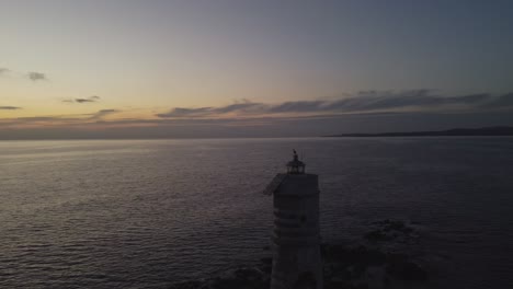 Wonderful-cinematic-aerial-drone-view-of-solitary-lighthouse-with-seagull-on-top