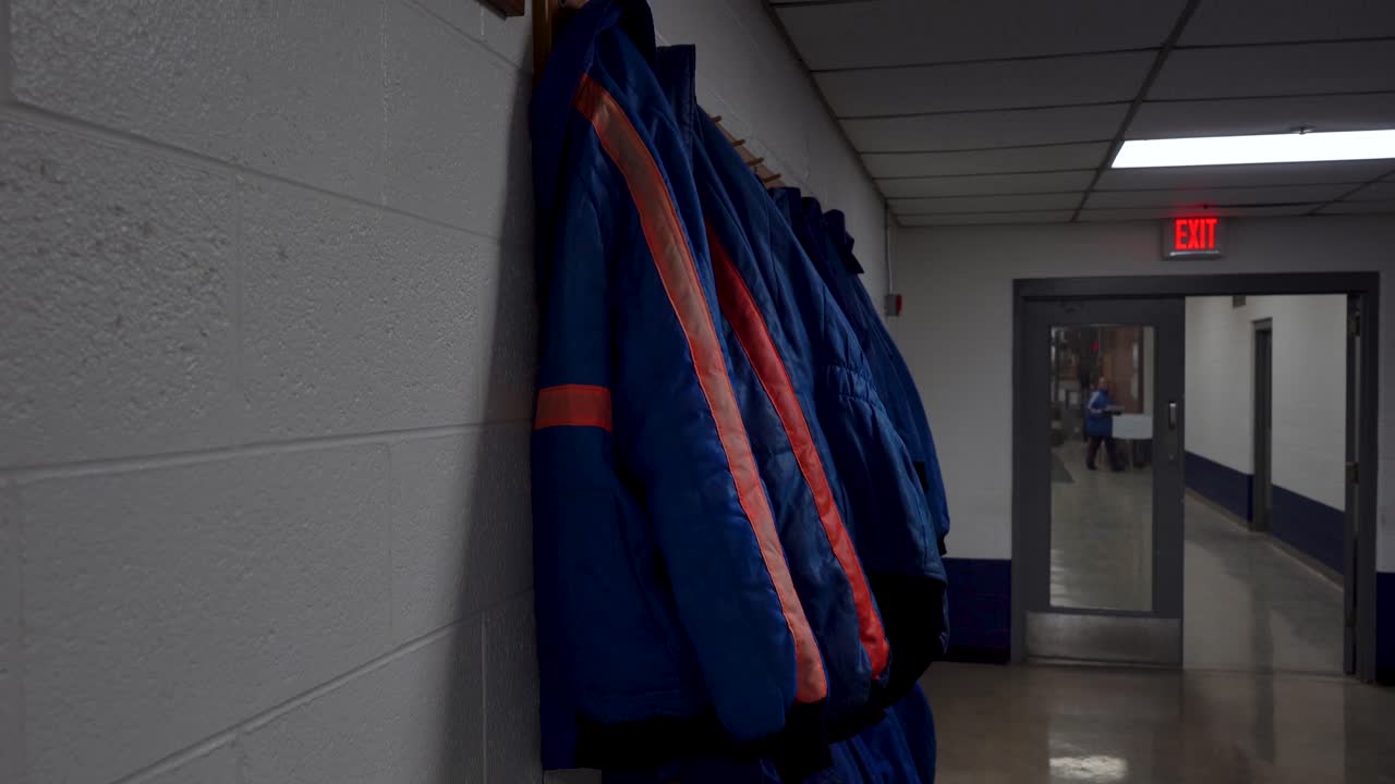 las chaquetas azules de la prisión de los reclusos prisioneros en la prisión en el hangar 4k