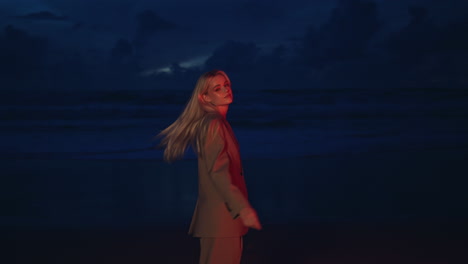 night model stepping ocean shore at dusk. portrait sexy blonde posing in suit