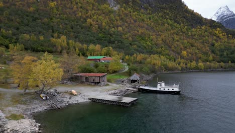 drone flies between old boathouse and sawmill on vike in eikesdsal, in molde municipality in norway