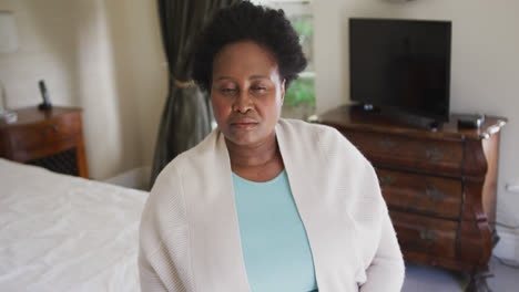 Thoughtful-african-american-senior-woman-sitting-on-the-bed-at-home