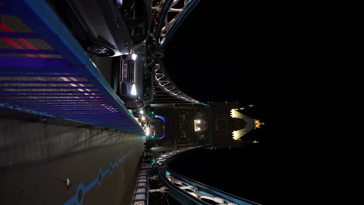 London Tower Bridge bustling at night with cars and people captured in vertical timelapse
