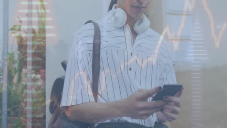 animación de gráficos y flechas hacia arriba sobre hombre biracial con bolsa de viaje desplazándose en el teléfono inteligente