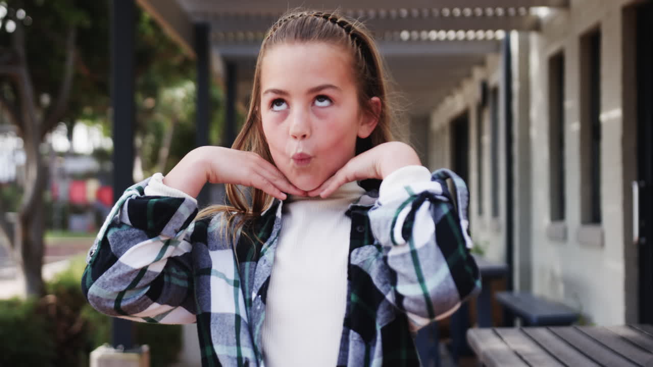 Confident girl standing outside school building, smiling and enjoying day