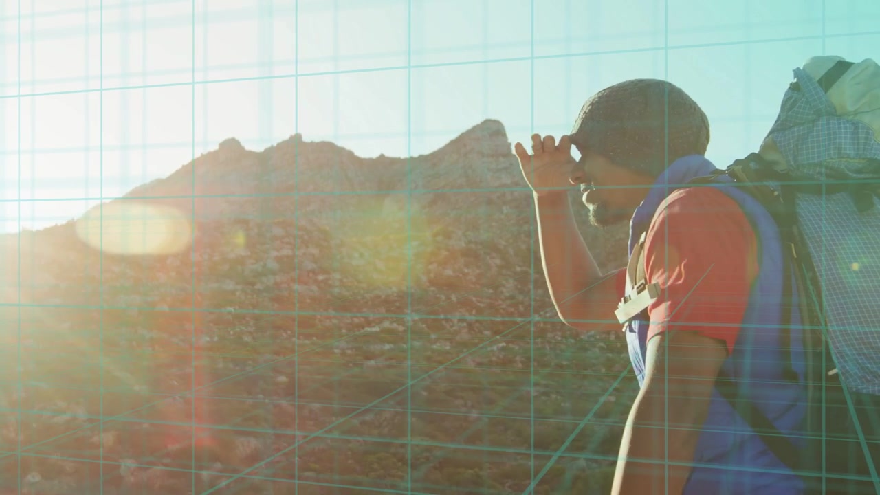 Male hiker walking ridge, low sun causing route scanning while grid tech and lens flare guiding
