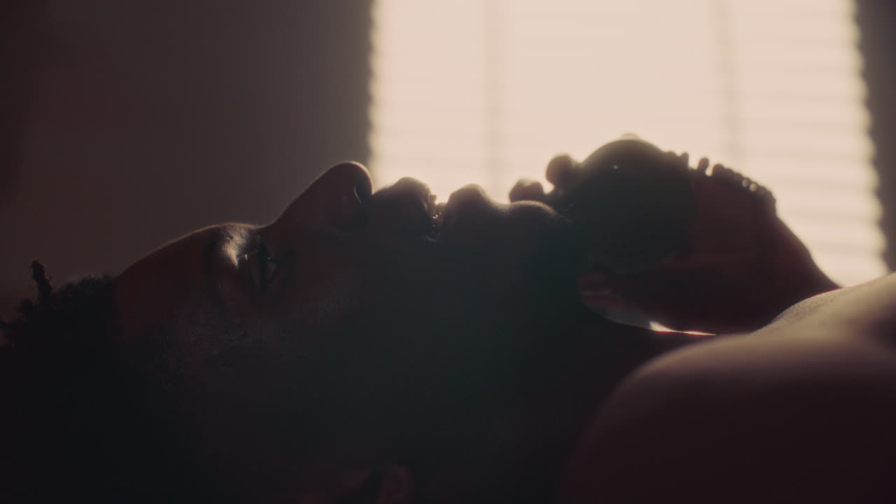 Relaxed African American Man Lying on Bed and Chatting on Telephone
