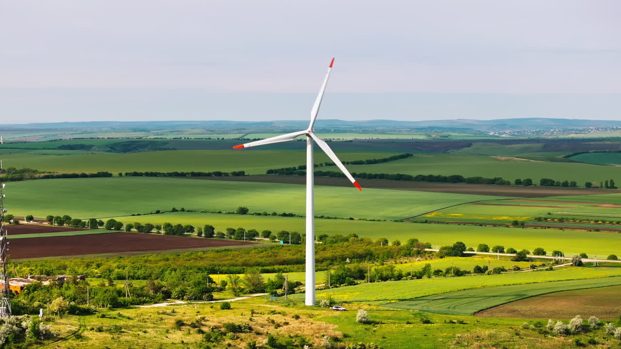 Aerial drone view of a wind turbine in a field on a cloudy day