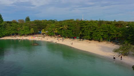 aerial zoom out of people on tropical white