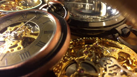 old fashioned pocket watches and mechanical watch movements revealed out of shadows