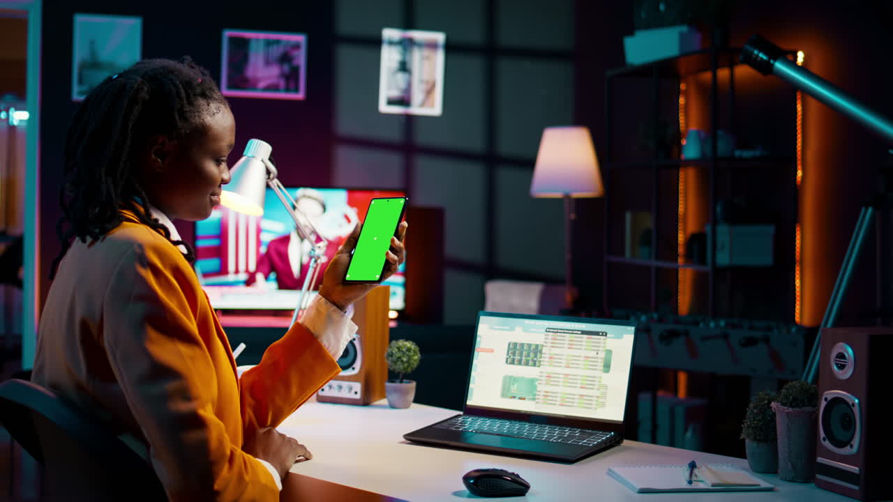 Student uses greenscreen on phone layout while she examines cash plan software