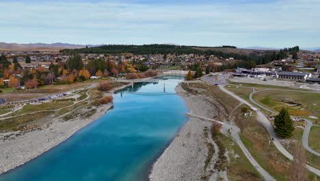 drone footage captures lake tekapo's vibrant autumn colors and serene waters, highlighting the church of the good shepherd