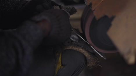 using a belt sander to produce handles of a steel pan cookware in a factory