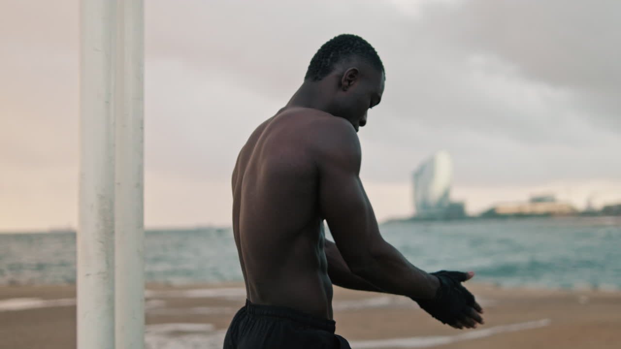 Strong African American Man Stretching Arms Outdoors Near Ocean