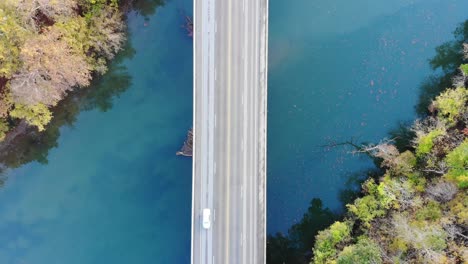 Toma-Aérea-De-Arriba-Hacia-Abajo-De-Un-Puente-Sobre-Un-Río-Verde-azul