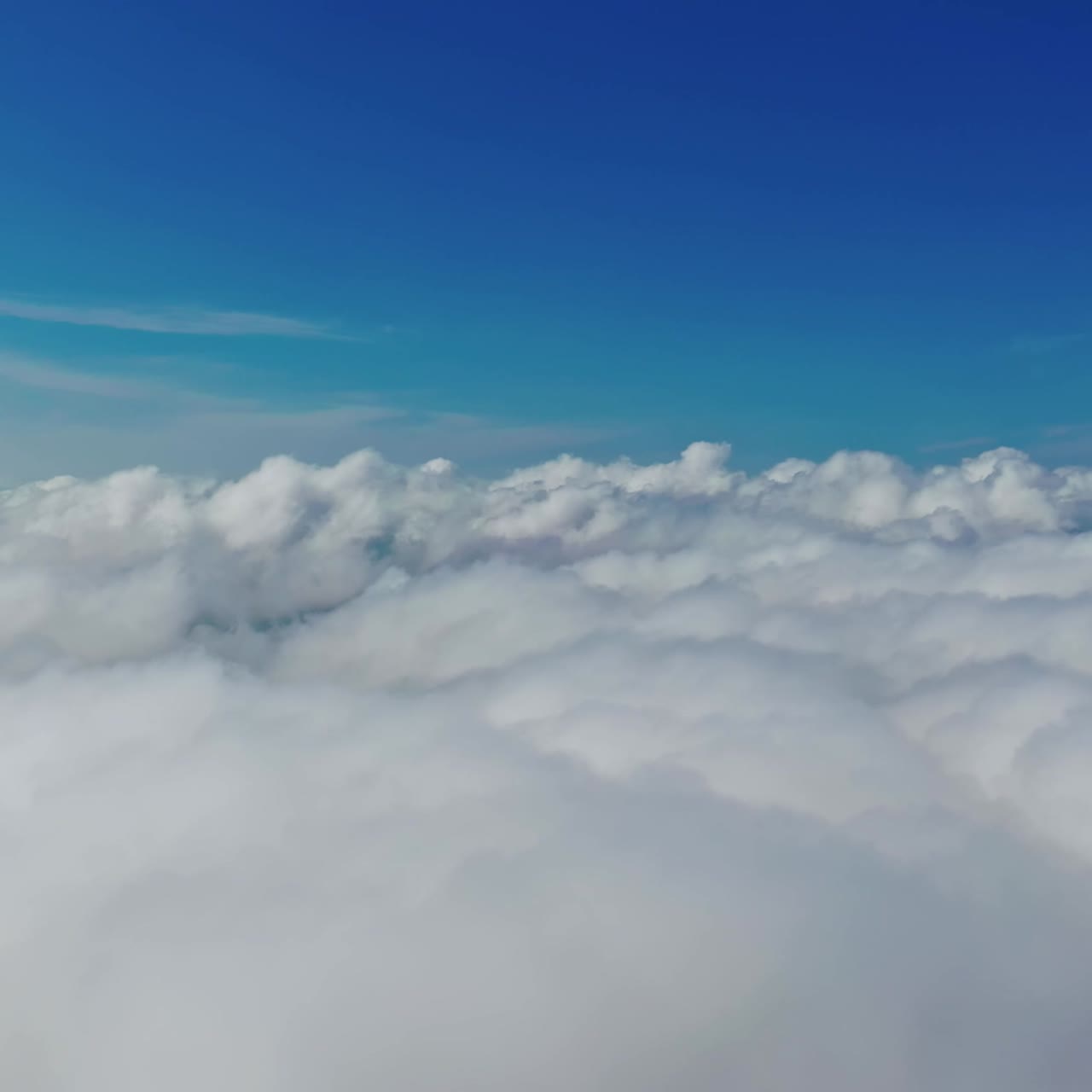 Blue sky and white clouds background. Stunning footage above clouds with blue sky. Travelling by air background. Real time footage. Aerial view.
