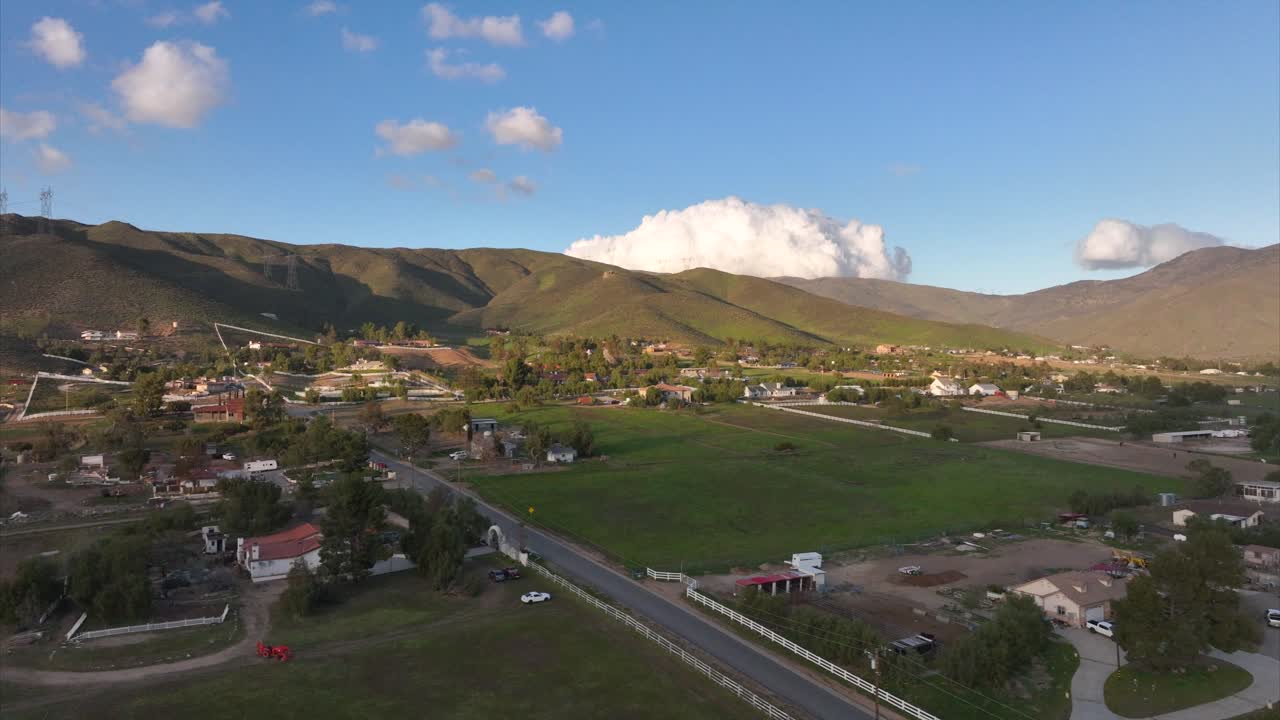 vista aérea del sobrevuelo del campo rural de los estados unidos a través de la zona residencial de desarrollo comunitario de la pequeña ciudad bajo el paisaje de montaña
