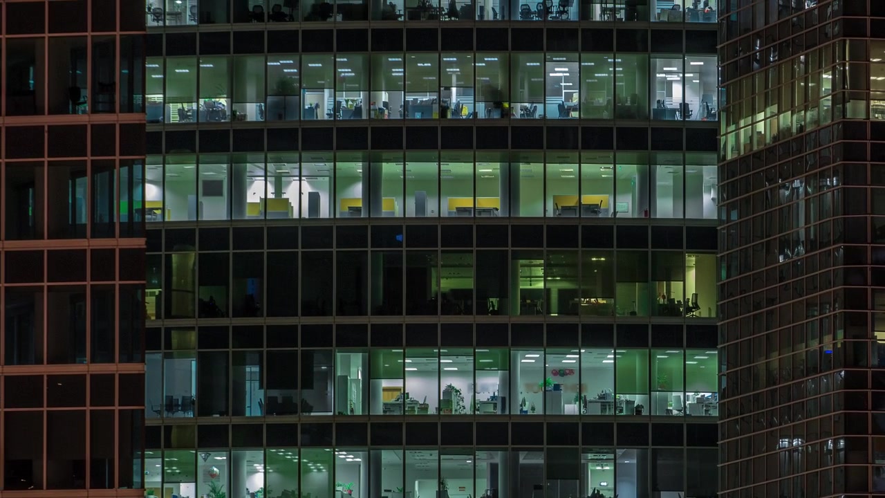 Close up view to panoramic office windows in Skyscrapers International Business Center of City at night timelapse from top