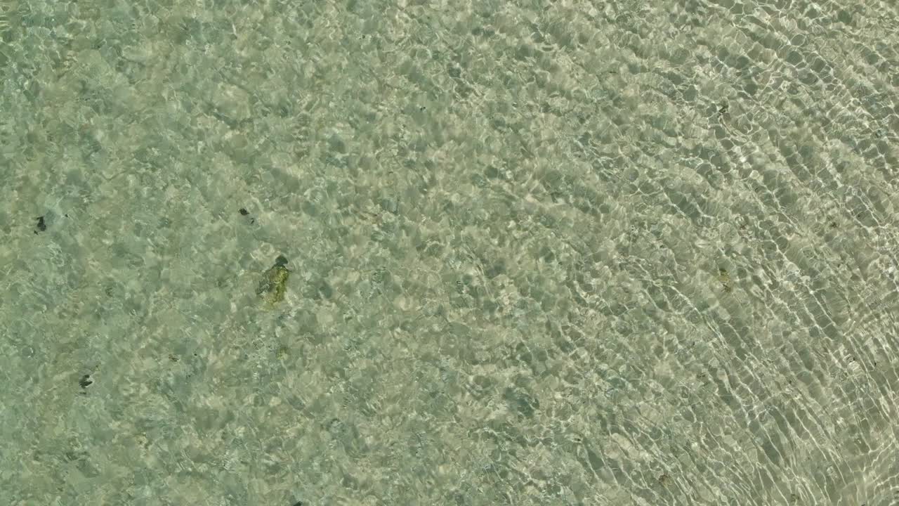 Aerial top down view from high altitude of green sea water texture. Azure ocean water. 4K Background of the water surface.