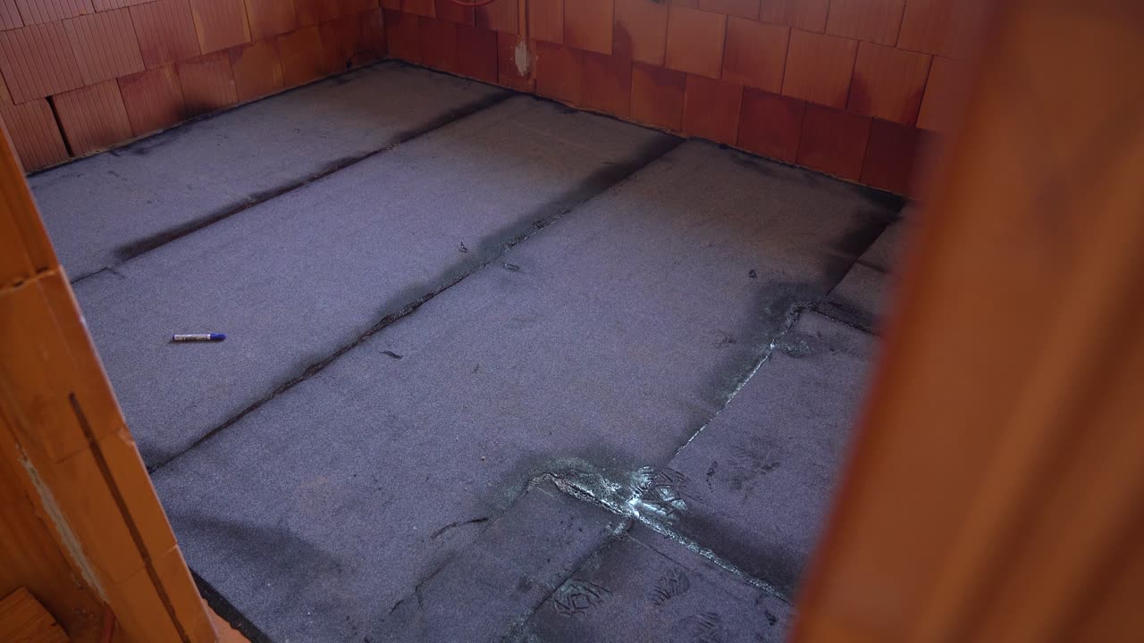 Bitumen waterproofing membrane applied on house floor with visible seams