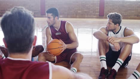 basketball players interacting while relaxing in the court