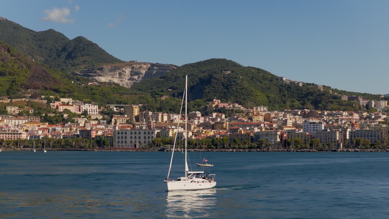 Teleobiettivo, drone che riprende una barca a vela al largo della costa amalfitana, giornata di sole, in Italia